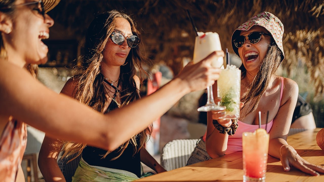 Group of friends at a beach bar, with a concerned woman in the middle.